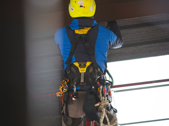 Man utilizing safety harness on construction site.